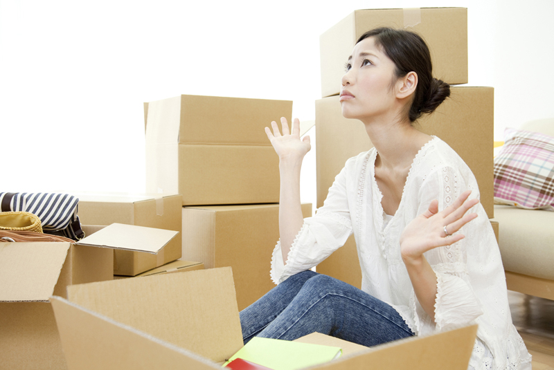 引越しの荷造りが進まずお手上げ状態の女性