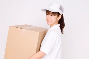 ダンボールを運ぶ引越し業者の女性スタッフ