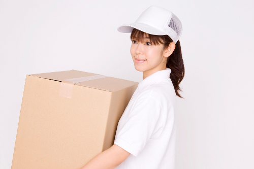 ダンボールを運ぶ引越し業者の女性スタッフ